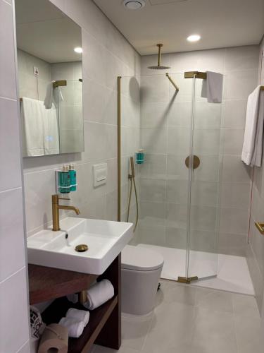 a bathroom with a sink and a shower and a toilet at Azores Book Hotel in Angra do Heroísmo