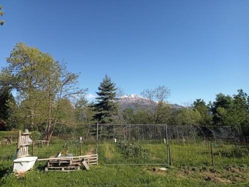 a field with a fence and a boat in the grass at Un Soggiorno nella Natura in Valperga
