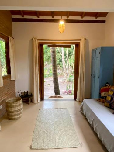 a bedroom with a bed and a palm tree at Vila Pitanga - Arandis in Marau