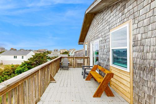 a wooden bench sitting on the balcony of a house at Tarpon Drive Hideaway Unit B in Avon