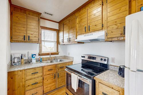a kitchen with wooden cabinets and a stove top oven at Tarpon Drive Hideaway Unit B in Avon