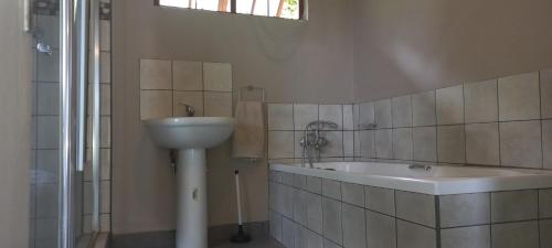 a bathroom with a sink and a bath tub at Taylor's Nest in Mancana