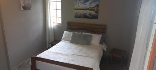 a bedroom with a bed with a pillow and a window at Taylor's Nest in Mancana