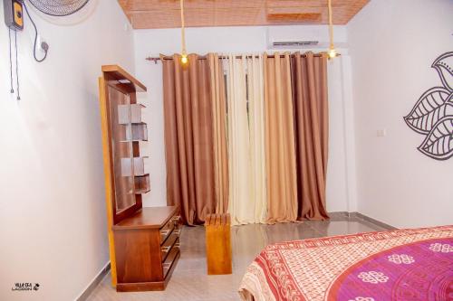 a bedroom with a bed and a window with curtains at Villa Sea Lagoon in Kamburugamuwa