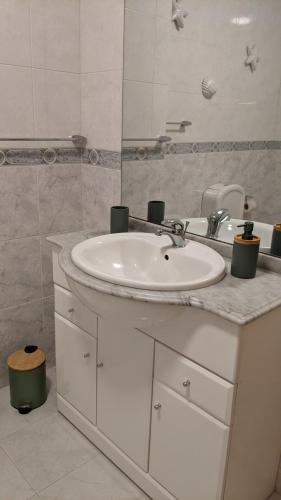 a bathroom with a white sink and a mirror at Sea and Nature Escape in Furadouro