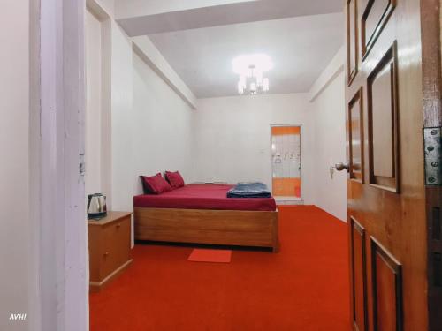 a bedroom with a bed and a red floor at Kinley Homestay in Darjeeling