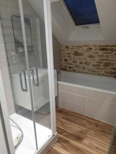 La salle de bains est pourvue d'une douche et d'une baignoire. dans l'établissement Maison renov-casi, à Nivillac