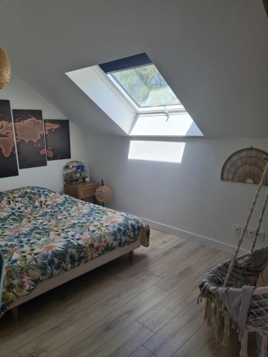 une chambre avec un lit et une lucarne dans l'établissement Maison renov-casi, à Nivillac