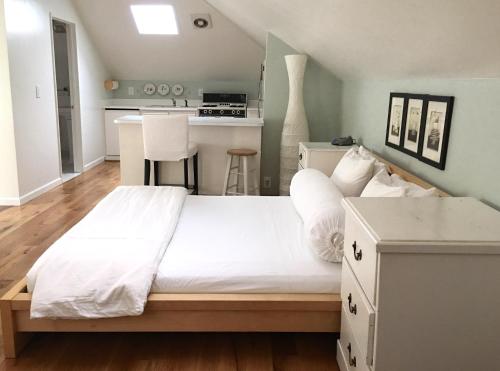 a bedroom with a white bed and a kitchen at Cowper Inn in Palo Alto