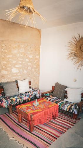 a living room with a couch and a table at IBI Surf House in Sidi Kaouki