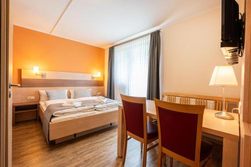 a hotel room with a bed and a desk at Gästehaus Zehmerhof bei Erding in Walpertskirchen
