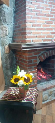 a vase of flowers sitting on a table next to a brick fireplace at Cabaña la Rinconada in La Marquesa