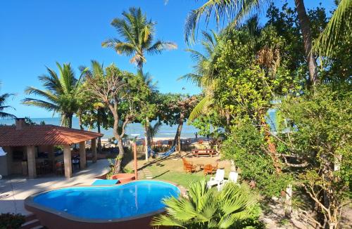 a view of the beach from a resort with palm trees at Pousada Marauá - Na beira do mar de Cumuru in Cumuruxatiba