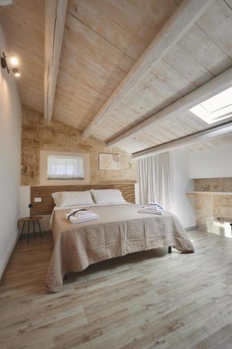 a bedroom with a large bed in a room with wooden ceilings at Dimora del Monte "I Limoni ","L Ulivo " in Ragusa