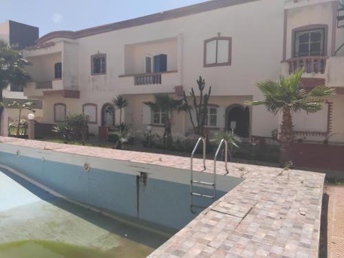 a house with a boat in the water in front at Wish is Bouzid in Sidi Bouzid