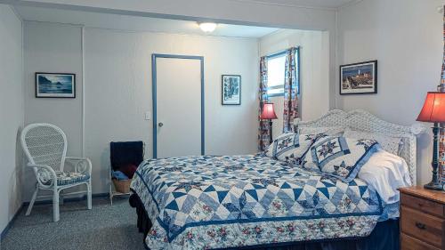 a bedroom with a bed and a chair and a window at PA Crows Nest Cottage in Port Angeles