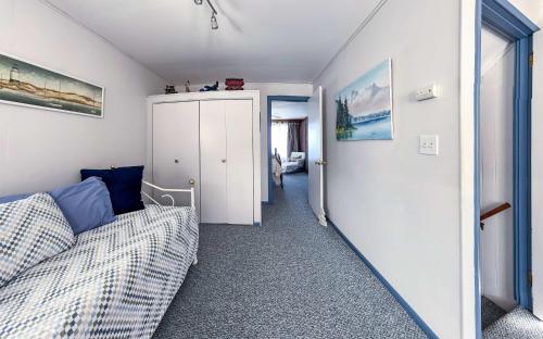a living room with a couch and a hallway at PA Crows Nest Cottage in Port Angeles