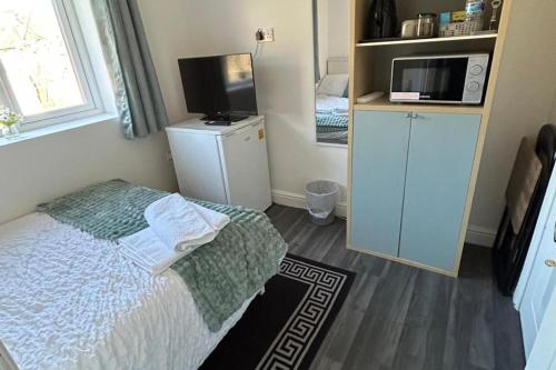a small bedroom with a bed and a microwave at Private Room with Ensuite Bathroom & Free Parking in Birmingham