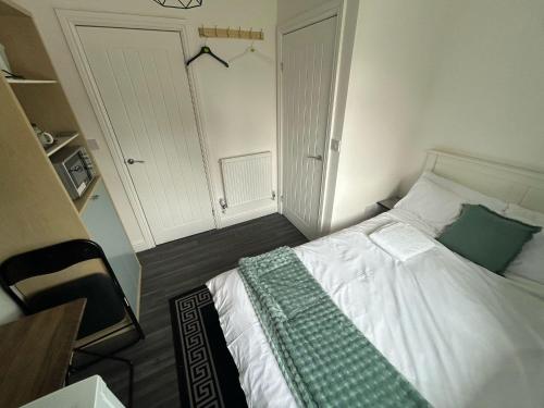 a bedroom with a bed with a green blanket on it at Private Room with Ensuite Bathroom & Free Parking in Birmingham