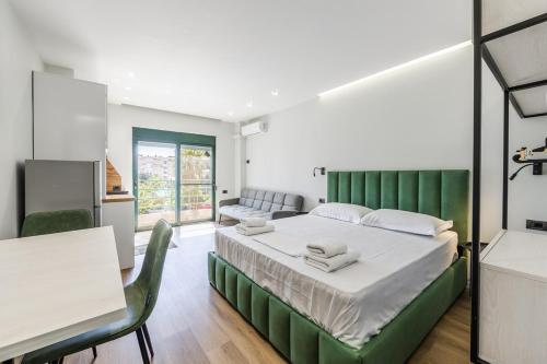 ein Schlafzimmer mit einem großen Bett mit grünem Kopfteil in der Unterkunft Studio Mare Blu by PS in Golem