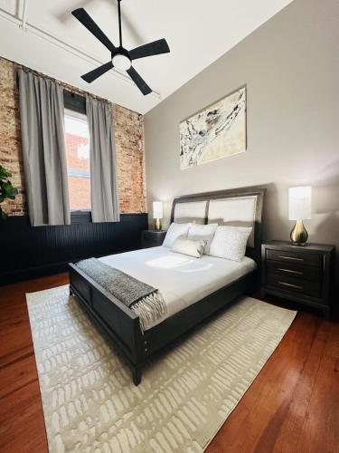 a bedroom with a bed and a ceiling fan at 547 Cherry Loft 201 - The Rookery - Luxe Property in Macon