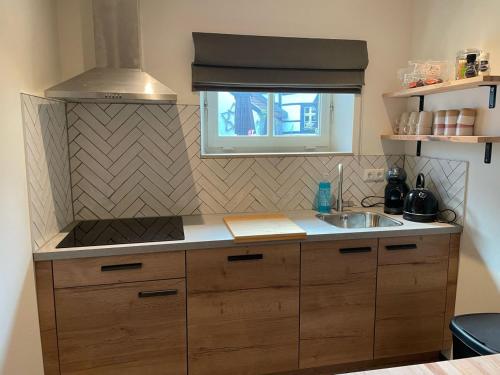 a small kitchen with a sink and a stove at Valley View Cottage 4 Authentic 6 guest cottage near Valkenburg in Voerendaal