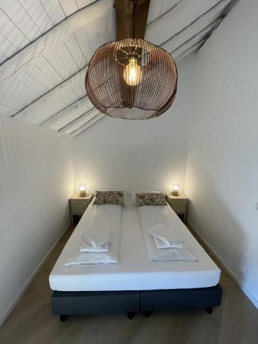a bed in a room with a chandelier at 17 4p Historical Cottage near Valkenburg in Voerendaal
