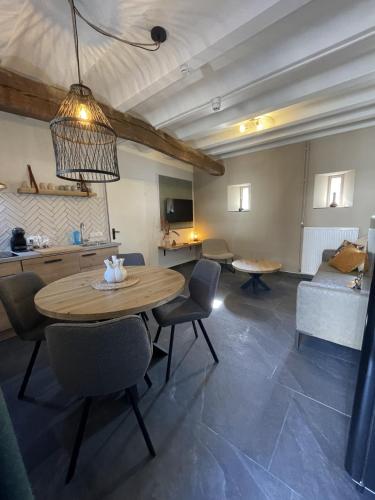 a living room with a table and chairs and a couch at 18 4p Authentic Cosy Cottage in Voerendaal