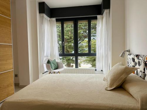 a bedroom with a large bed and a window at Maralfrente de Noja- 6020 in Noja