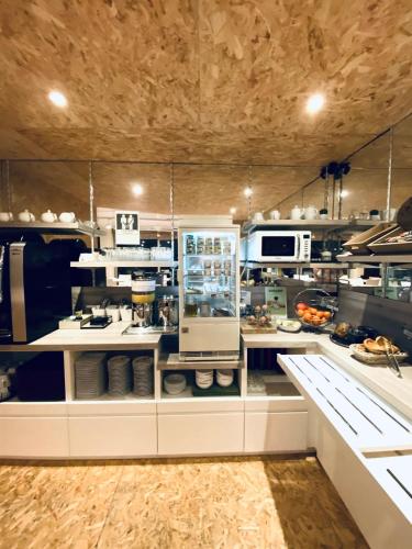 une grande cuisine avec comptoirs et appareils blancs dans l'établissement Brit Hotel Le Surcouf, à Saint-Malo