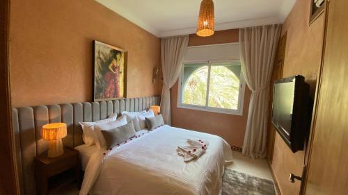 a bedroom with a bed and a window and a television at Dar El Hana 4 Bedroom Villa in Marrakech