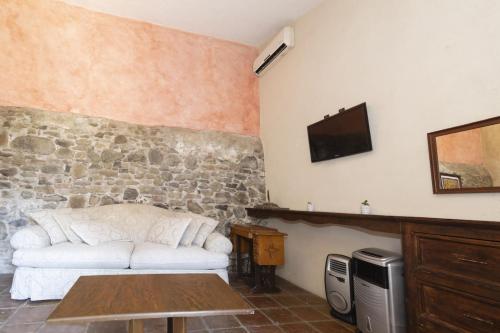 a living room with a white couch and a tv at Collection O Cachito Mio in Cholula