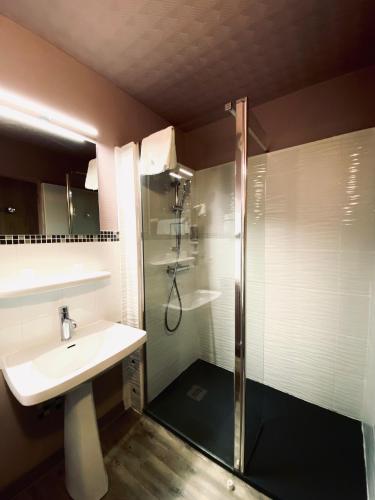une salle de bain avec douche et lavabo dans l'établissement Brit Hotel Le Surcouf, à Saint-Malo