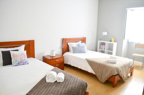 a bedroom with two beds with towels on them at A Casa da Ponte in Ribeira Grande