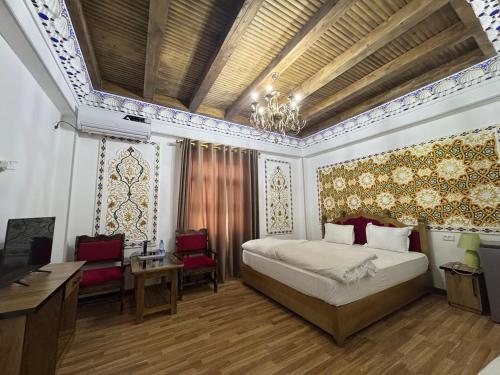 a bedroom with a bed and a desk and chairs at Asia Central Boutique in Bukhara