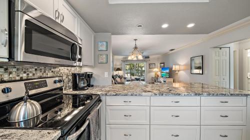 a kitchen with a stove and a microwave at Sunset Sanctuary in Longboat Key