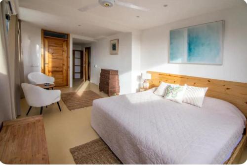 a bedroom with a white bed and a chair at Urban Boutique Hotel in Las Terrenas