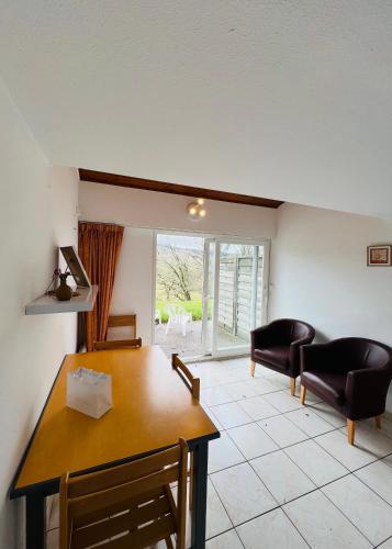 un salon avec une table et des chaises de salle à manger dans l'établissement Appartement 7 personnes base de loisirs des Bouldouires, à La Salvetat-sur-Agout