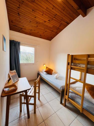 Cette chambre comprend 2 lits superposés, une table et un bureau. dans l'établissement Appartement 7 personnes base de loisirs des Bouldouires, à La Salvetat-sur-Agout