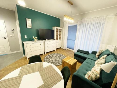 a living room with a couch and a tv at Apartament Drugi Dom Sztutowo Baltic Twins in Sztutowo