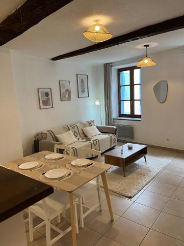 un salon avec une table et un canapé dans l'établissement Loft Bohème & cosy Lit King size, à Carcassonne
