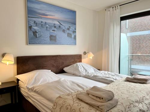 a bedroom with a bed with towels on it at Appartementhaus Seemöwe Grasmöwe in Grömitz