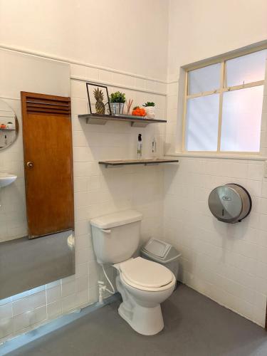 a bathroom with a toilet and a sink and a window at Traveler Hostel in San Gil