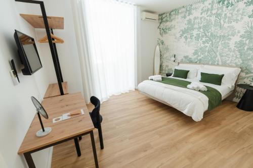 a bedroom with a bed and a table and a desk at xenia apartments & suite in Siracusa