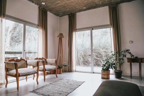 a living room with two chairs and large windows at Benita Haus in La Estafeta