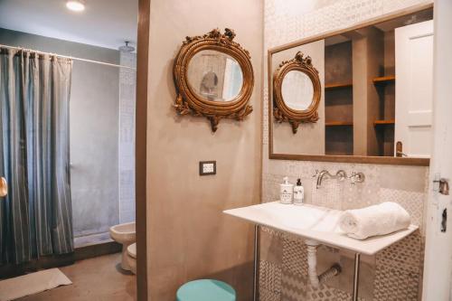 a bathroom with a sink and mirrors and a toilet at Benita Haus in La Estafeta