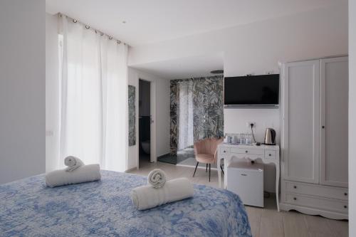 Un dormitorio blanco con una cama y un escritorio. en BED INN - Palazzo Urbe, en Olbia