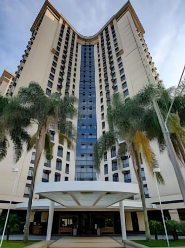 a building with palm trees in front of it at Suíte Luxo Congonhas com sofá cama (Apto 2005H) in Sao Paulo