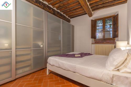 a bedroom with a white bed and a wooden ceiling at Casa Dei Briganti by TuscanyWeGo in Massa