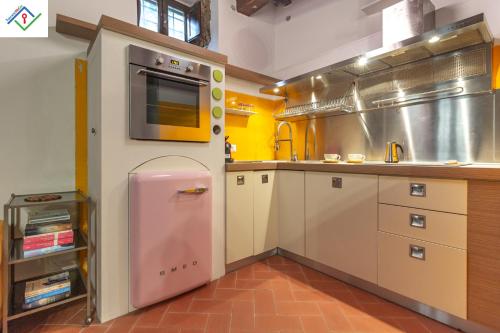 a large kitchen with a pink refrigerator in it at Casa Dei Briganti by TuscanyWeGo in Massa